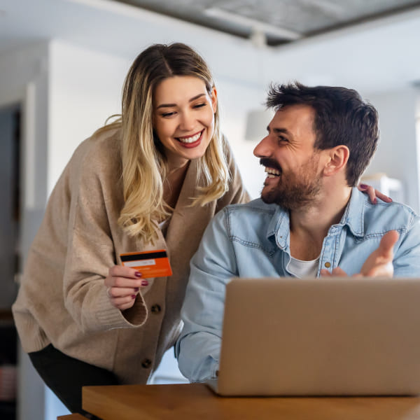 Un couple utilisant une carte de crédit pour acheter en ligne.